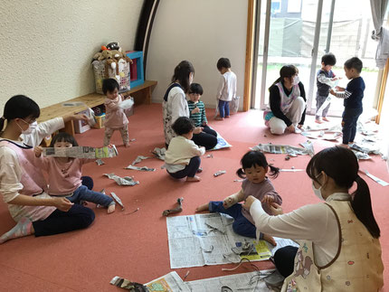 そらぐみさんとひかりぐみさんは新聞紙遊びをしました。遠足を思い出して新聞紙を敷物にして「おにぎりだよ！」「たまごやき！」「おちゃ、ごくごく。」とお弁当を作ってる子もいました。