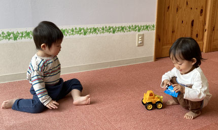 お友達と一緒。お気に入りの玩具を見せてあげています。