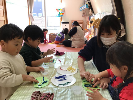 ほしぐみさんの1つ目のグループはのりを使って毛糸を貼って鬼のお面を作りました。「のりがぺたぺたする！」とのりの感触を楽しみながら手でのりを広げて、「あおにしようかな？」「つぎはあか！」と好きな色の毛糸を選んで貼っていました！