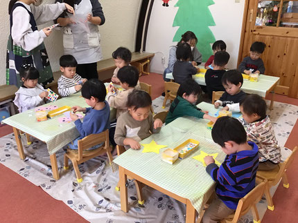 そらぐみさんは、シール貼り遊びをしました。「キラキラシールにする！」「いろんなかたちがあるね！」と、好きなシールを選んで星や長靴やリボンの形の紙に貼りました。