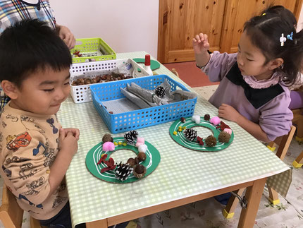 ほしぐみさんはクリスマスに向けてリース作りをしました。段ボールの台紙にまつぼっくりやどんぐり等好きな木の実を選んで飾り付けました。きれいに整列させて並べる子やバランスを考えて飾る子など、個性豊かなとても素敵なリースが出来上がりました。