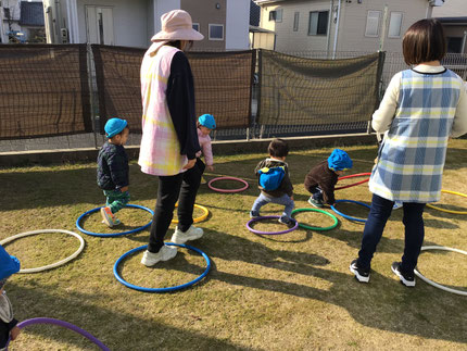 その後は、芝生の上に置いたフラフープをピョンピョン飛んで遊びました。保育士と一緒に次々とフラフープを並べてくれる子や、「ブーン！くるまです！」「しゅっぱつ！」とフラフープをハンドルにして、運転手さんになりきって遊んでいる子もいました！