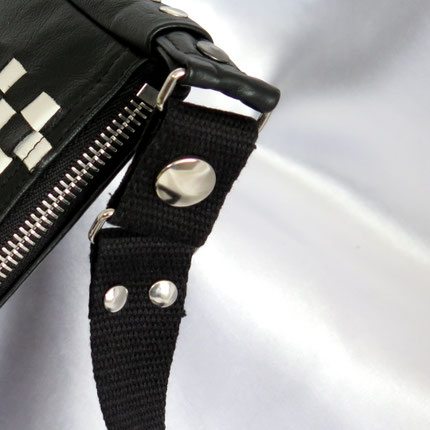 Crossbody für Männer an einem Zaunpfahl