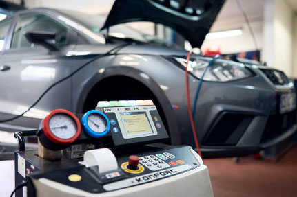 Ein Klimaservicegerät neben einem Fahrzeug bei einer Untersuchung in der Werkstatt vom Autohaus Fischer