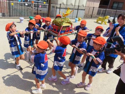 夏祭りで子どもがおみこしを担いでる様子