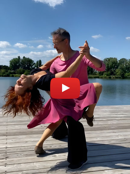 Ein Tanzpaar auf einem Steg am Wasser, das Cha-Cha-Cha tanzt