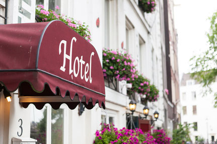 Hotel-Eingang mit Blumen als Symbol für Übernachtung und Unterkunft