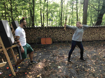 Teilnehmer beim Bogenschießen im Wald bei Teamevent