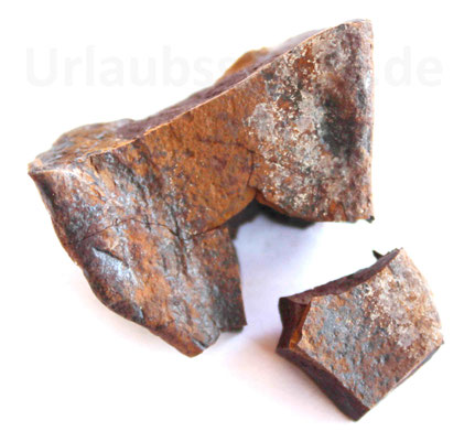 In der Mitte und am Rand zerbrochenes Toneisenfragment.