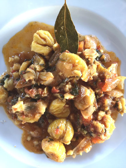 in Olivenöl gekochte Eßkastanien mit Gemüse und Lorbeerblatt auf einem Teller