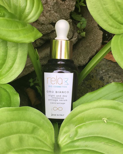 Siero antiage della linea Oro Bianco di RelaxBioCosmetics in mezzo a foglie di loto