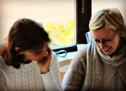 Anja Orywol und Steffi Eikel bei der Arbeit vor einem Fenster mit gesenktem Blick zum Thema Essstörungen in der traditionellen chinesischen Medizin 5 Elemente Ernährung Seminar