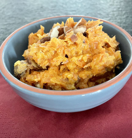 Karotten-Halwa, ein süsses ayurvedisches Dessert aus geriebenen Karotten, Milch oder Pflanzenmilch, Ghee und Gewürzen wie Kardamom, warm serviert und nährend.