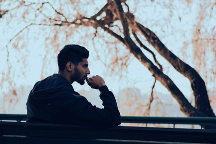 A man with his chin on his hand. He may be thinking deeply, or might be worried about something. Mindfulness can help with the latter.