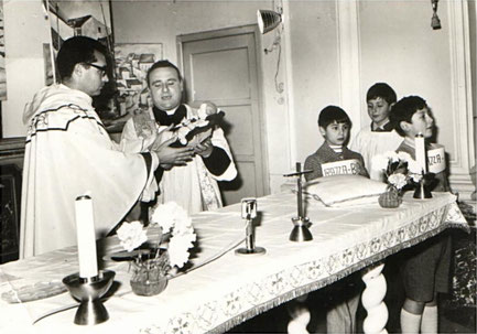 Natale 1968: Don Vincenzino col "Predicatore" Domenicano Padre Sofia. Sullo sfondo il Presepe con i quadri dei quartieri della Parrocchia.