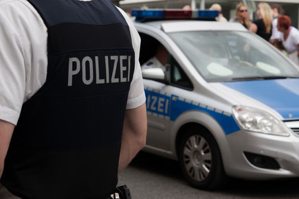 Ein Polizist und ein Streifenwagen