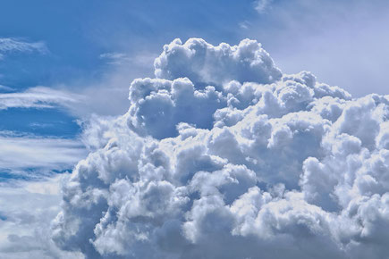 Eine große, fast formatfüllende Cumuluswolke mit scharf umrissenen Rändern. Im Hintergrund noch blauer Himmel mit einigen Schleierwolken.