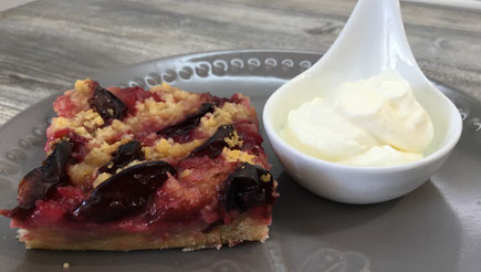 Frisch gebackener Pflaumenkuchen fertig angerichtet aus einem Desserteller