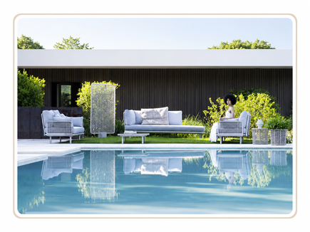 Arredo outdoor con divani, poltrone e tavolini da esterno disposti a bordo piscina in ambiente elegante.