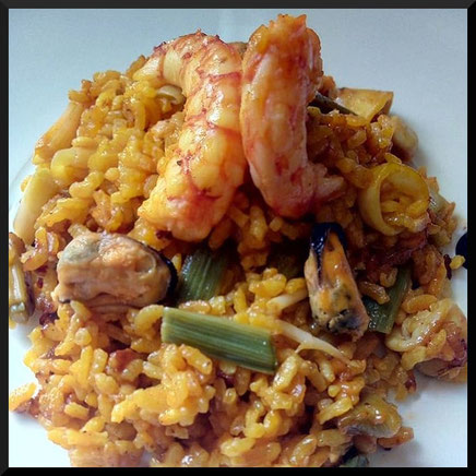 Paella arroz y marisco con ajos tiernos típica de la gastronomía valenciana.