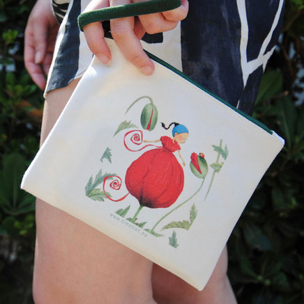 Une trousse Timeliot avec un coquelicot imprimé est tenu par une main de femme