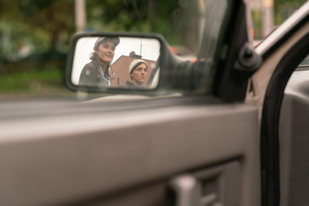 Das Bild zeigt die beiden Autorinnen Karolina und Kristina Dreit, die sich in einem Autospiegel spiegeln.
