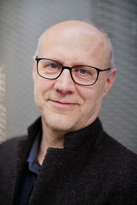 Das Bild zeigt Matthias Drilling mit kurzen grauen Haaren und Brille, der in die Kamera lächelt.