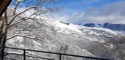Cette photo est une vue du balcon sur les montagnes enneigées
