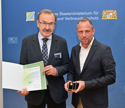 Staastminister Thorsten Glauber überreicht Wolfgang Reichenberger die Ausszeichnung Grüner Engel. 