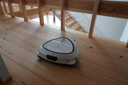 吹き抜けに面した木の格子手摺。 お掃除ロボットは、格子の隙間へ自然に入り込み、段差を認識しながら静かに向きを変えていきます。 家電が無理なく機能することも、暮らしやすい住まいをつくる大切な設計のひとつです。