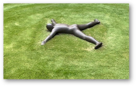 Körperregionen Yogatherapie Einzelunterricht Bild: Skultpur eines Menschen in Bauchlage auf Rasen