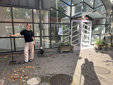 Martha und Julie (Schatten) beim Laubfegen.