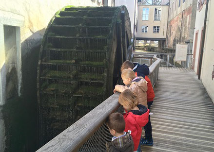 Kinder bestaunen altes Wasserrad