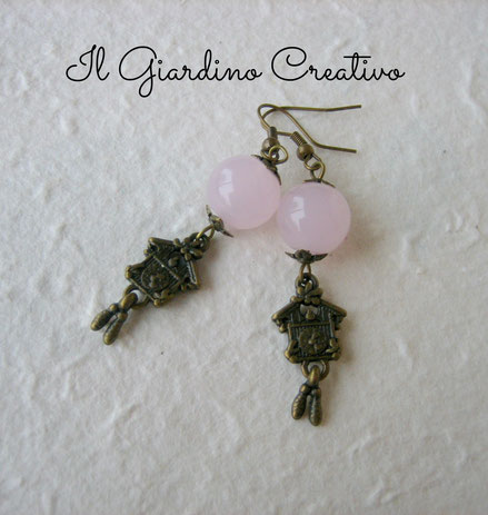 Orecchini "Cucù" realizzati con charms color bronzo antico e perle in vetro rosa opalescenti. Dimensioni: lunghezza 4.3cm circa