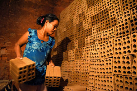 Une cambodgienne travaille dans une fabrique de briques dans la banlieue de Phnom Penh, le 11 décembre 2018 (AFP TANG CHHIN Sothy)