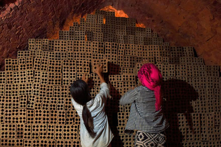 Des femmes entreposent des briques dans une manufacture de briques, près de Phnom Penh, le 11 décembre 2018 (AFP TANG CHHIN Sothy)