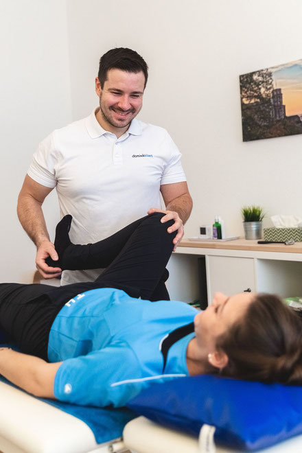 Dominik Klaes behandelt als Physiotherapeut eine Patientin am Knie in seiner Praxis für Physiotherapie in Heidelberg