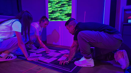 Gemeinsam rätseln drei Personen im Escape Room in der Region Luzern. Das Rätselspiel findet indoor statt und ist wetterunabhängig für ein Regentag geeignet.