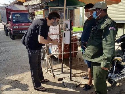 Contrôle de température et désinfection des mains à l'alcool avant d'entrer dans le quartier de l'église à Areyksat.