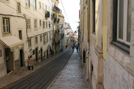 Schmale Gasse in der Altstadt von Lissabon, in der Mitte sieht man die Trambahngleise ©My own Travel Städtereise Lebendiges Lissabon