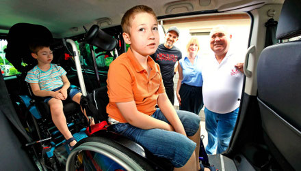 Jannes (vorne) und Elian Theobald finden mit ihren Rollstühlen im neuen Auto genug Platz. Adrian Schmitz, Andrea Brill und Marc Weisgerber (von rechts) sind zufrieden mit der Spendenaktion. Foto: Dieter Ackermann