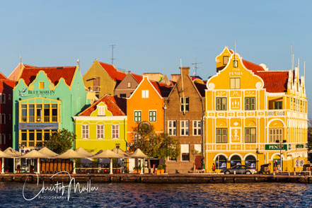 Willemstad, Curaçao's capital, is a breathtaking panorama of vividly painted colonial buildings lining a sparkling turquoise harbor, crowned by the iconic floating Queen Emma Bridge