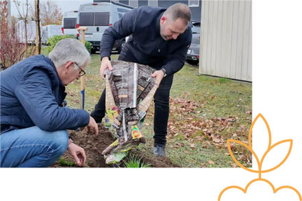 Dirk Fischer und Sebastian Fischer pflanzen einen Apfelbaum vor dem Autohaus Fischer in Celle.
