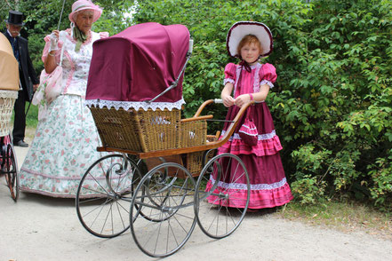 Mädchen mit historischen Kinderwagen