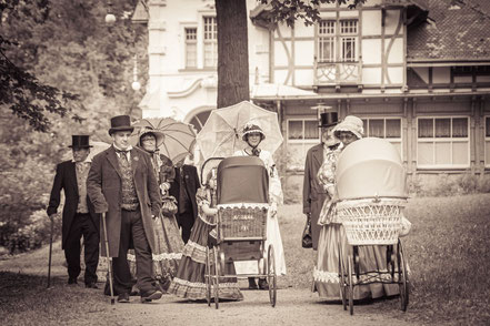 Biedermeiergruppe flaniert im Park