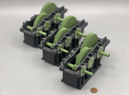 3 gleich Getriebemodelle, 3D-gedruckt in grau und grün designed in Industrieoptik mit 2 Getriebestufen Modul 1 und mit Miniaturschrauben verschraubt.