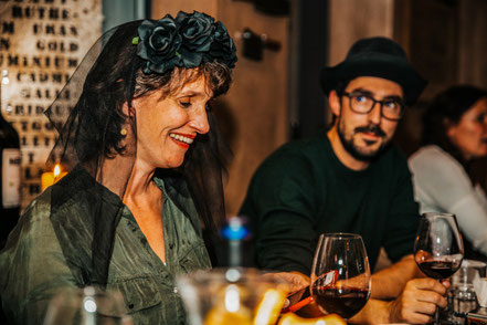 Eine Frau mit Schleier sitzt am Teamanlass im Restaurant. In ihrer Rolle geniesst sie das inteaktive Krimidinner. Dieser Teamevent wird ihr Erinnerung bleiben.