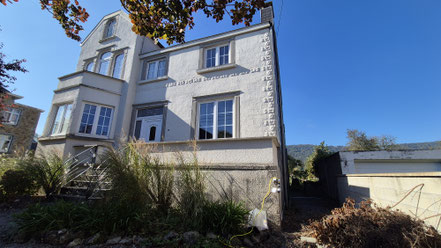 Façade blanche en crépi avec tour de fenêtre en pierre