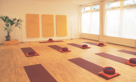 Heller Yogakursraum mit ausgelegten Yogamatten
