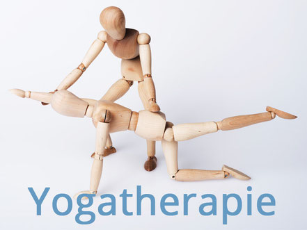 Yogatherapie - Zwei Holzpuppen stellen eine Yogasituation nach. Bild: C. Schuessler - Fotolia